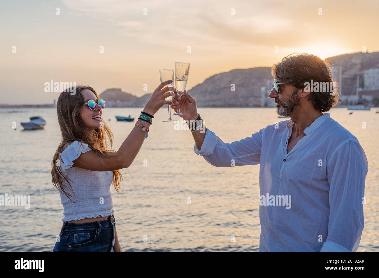 Vater und junge Tochter klirren Gläser Wein und lachen Wir feierten ein Familientreffen am Abend im Resort Stockfoto