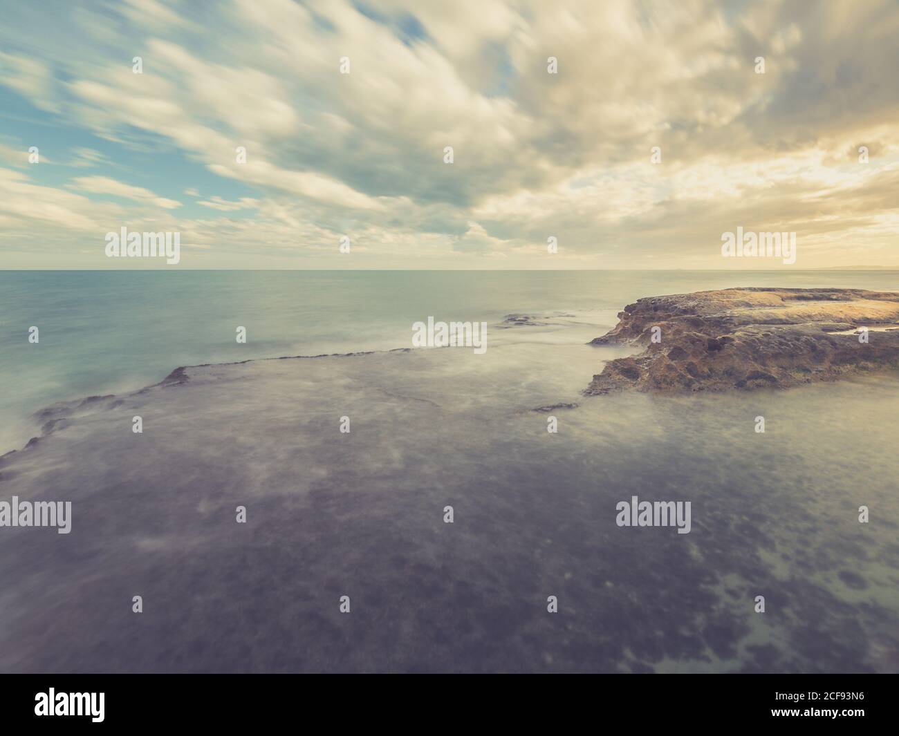 Felsige Küste von blau schäumenden Meer auf dem Hintergrund gewaschen Himmel mit Wolken Stockfoto