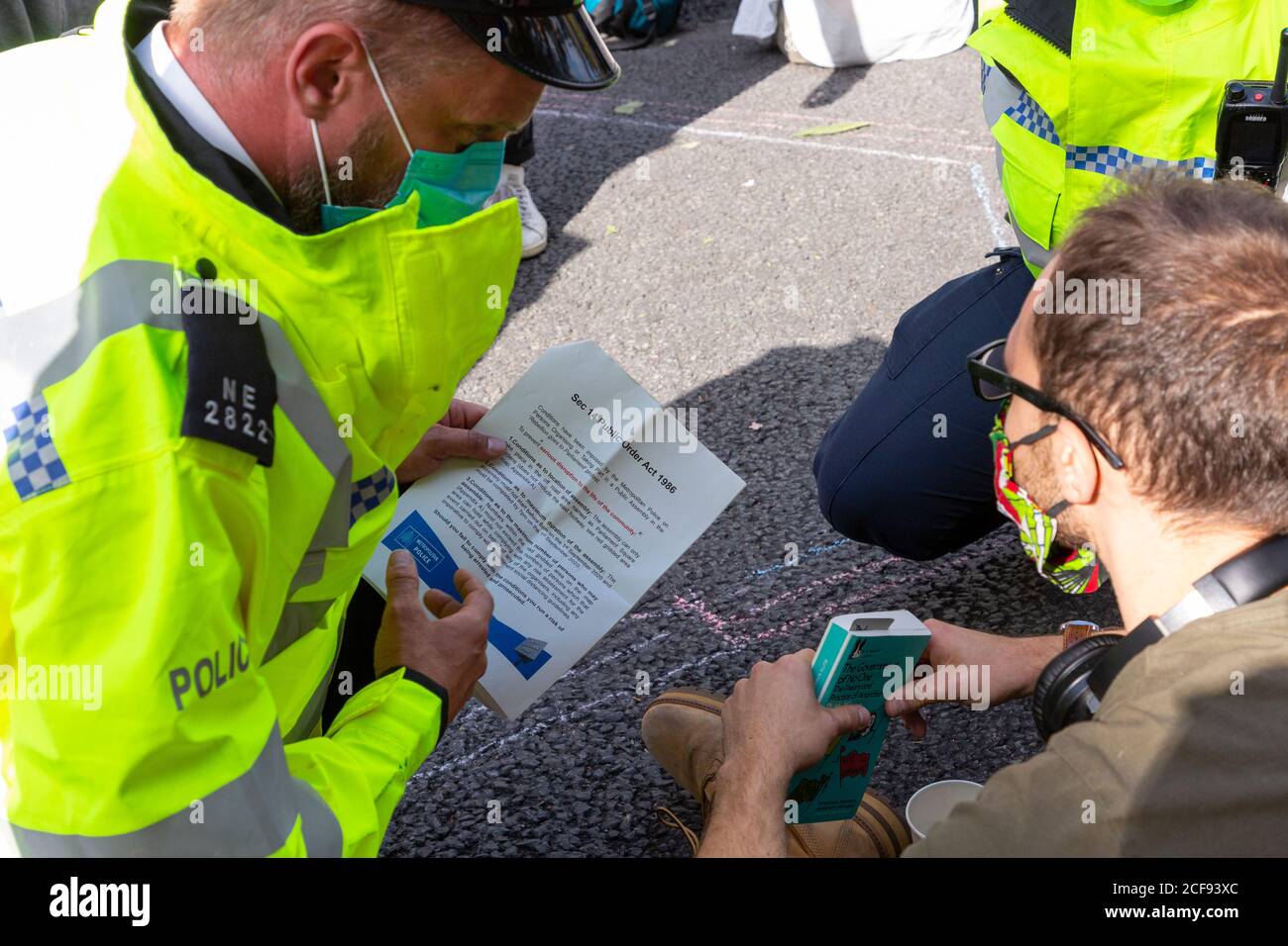 Ein Polizeibeamter liest einem Protestierenden während der Extinction Rebellion Demonstration, London, 1. September 2020, einen Befehl der Sektion 14 vor Stockfoto