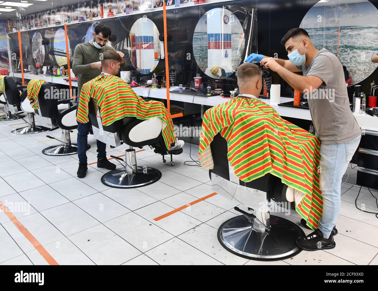 Barber bei der Arbeit tragen Gesichtsmasken in Unisex Friseursalon in Shrewsbury, Großbritannien, während der Covid 19 Pandemie Stockfoto