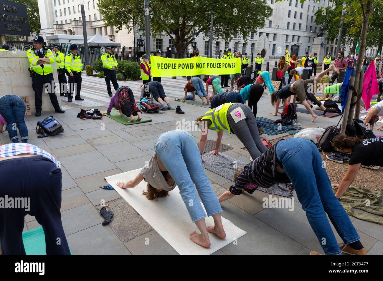 Protestierende schlagen Yoga-Posen vor New Scotland Yard während der Extinction Rebellion Demonstration, Westminster, London, 1. September 2020 Stockfoto