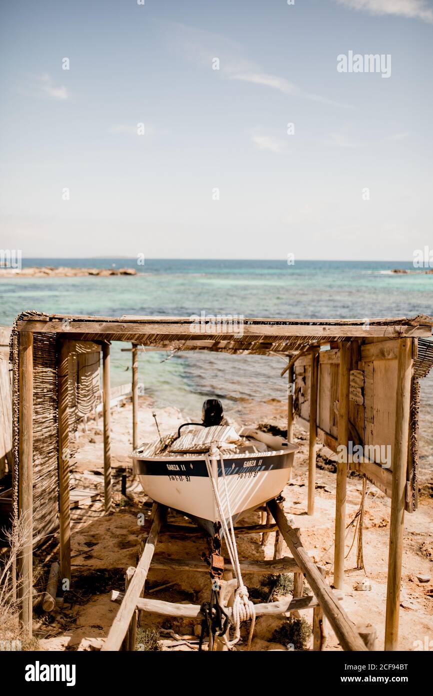 Boot an Land unter hölzernen Baldachin am Sandstrand festgemacht Sommersonne Stockfoto