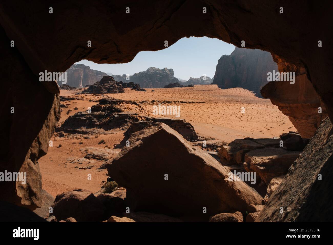 Sandy Wadi Rum Tal in der Nähe des Eingangs der felsigen Höhle auf Sonniger Tag in Jordanien Stockfoto