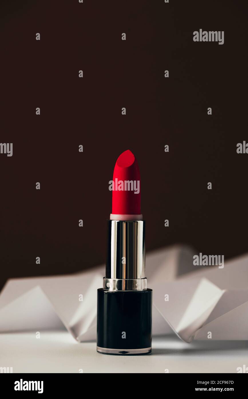 Roter Lippenstift auf erhabenen weißen Chevron, Produkt und Make up modernes Konzept Stockfoto