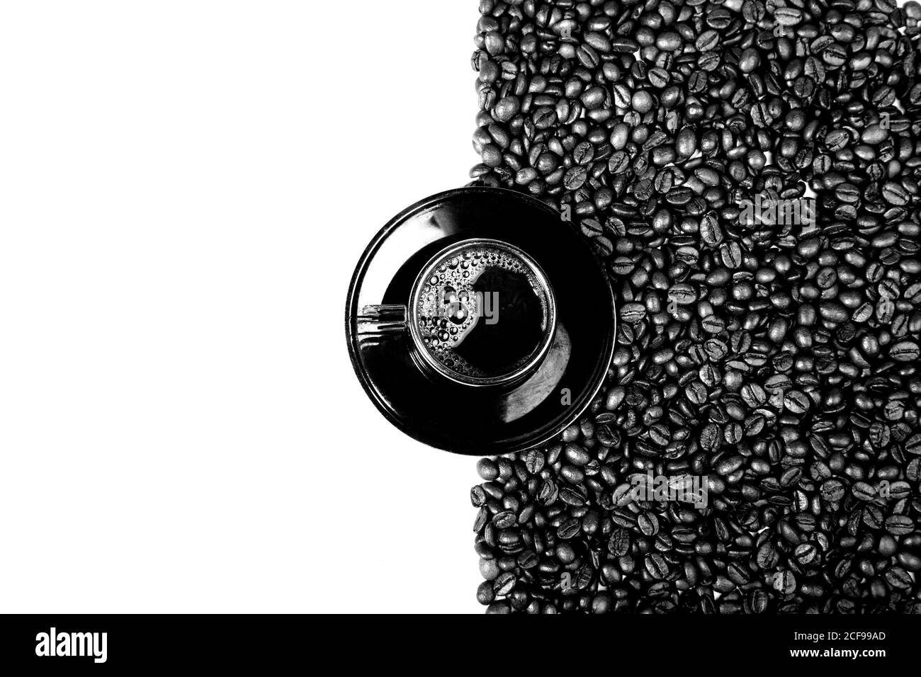 Draufsicht auf schwarze Tasse Kaffee auf Teller mit Kaffeebohnen isoliert auf weißem Hintergrund Stockfoto