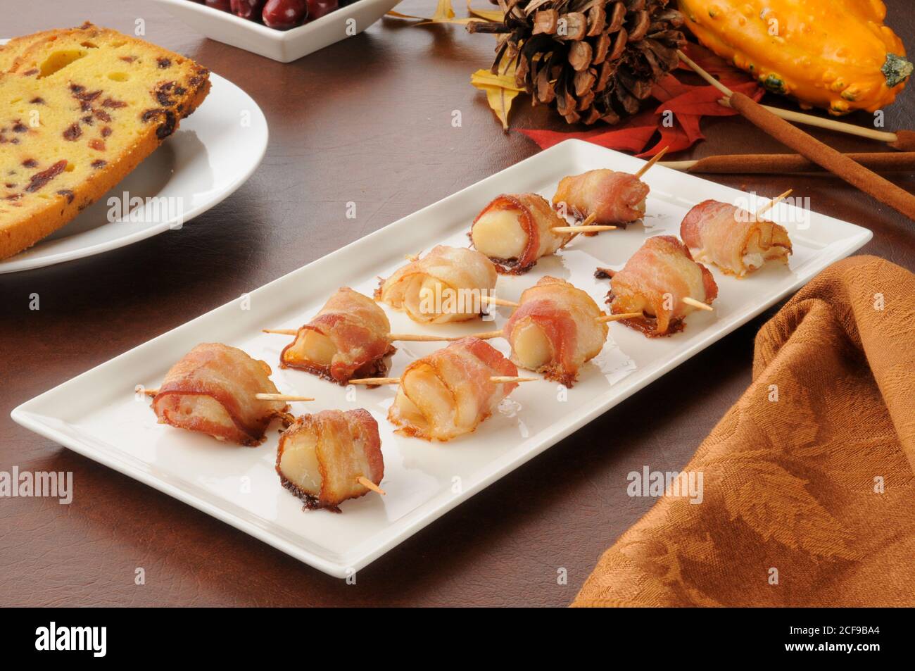 Ein Tablett mit Jakobsmuscheln in Speck und Cranberry-Brot eingewickelt Stockfoto