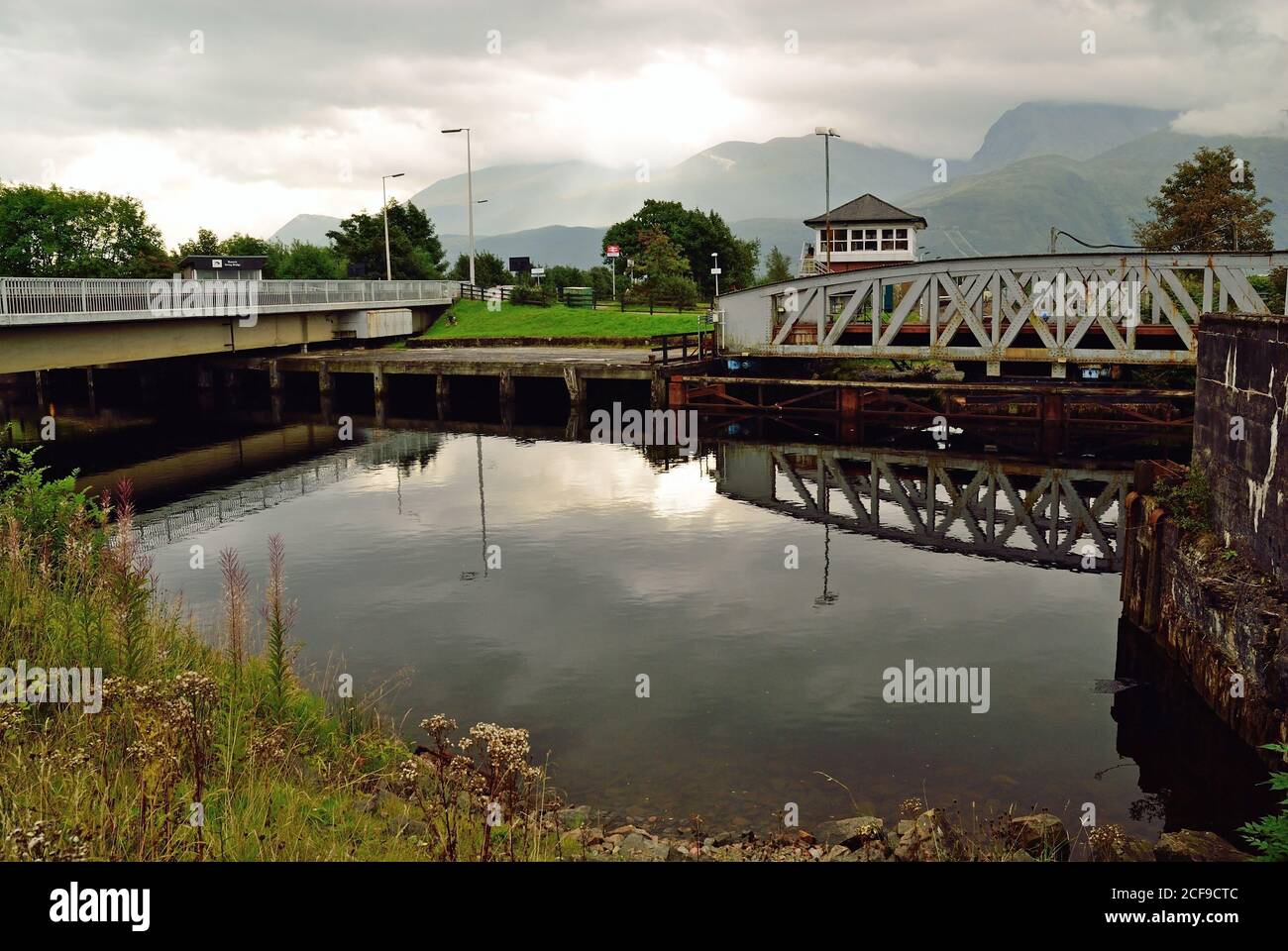 Banavie Drehbrücken über den Caledonischen Kanal. Die Eisenbahnbrücke auf der rechten Seite wird gerade geöffnet, damit eine Yacht durchfahren kann. Stockfoto