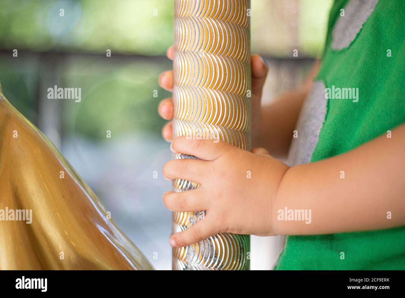 Neugieriges kleines Kind auf bunten beweglichen Karussell auf Messe Stockfoto