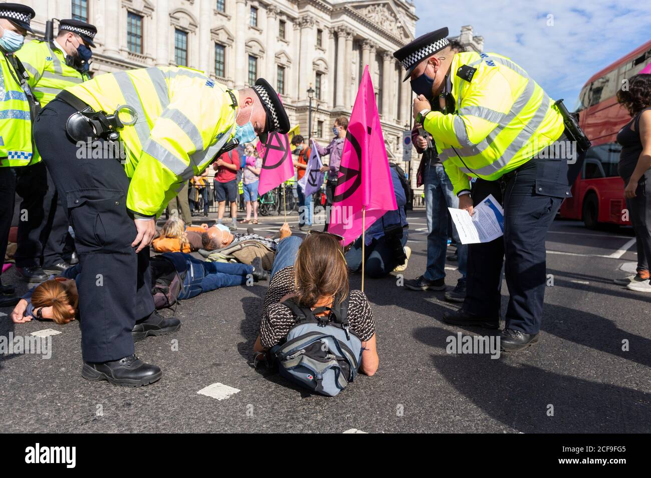 Polizeibeamte sprechen mit einem Protestierenden, der die Straße blockiert, Demonstration der Rebellion des Aussterbens, Parliament Square, London, 2. September 2020 Stockfoto