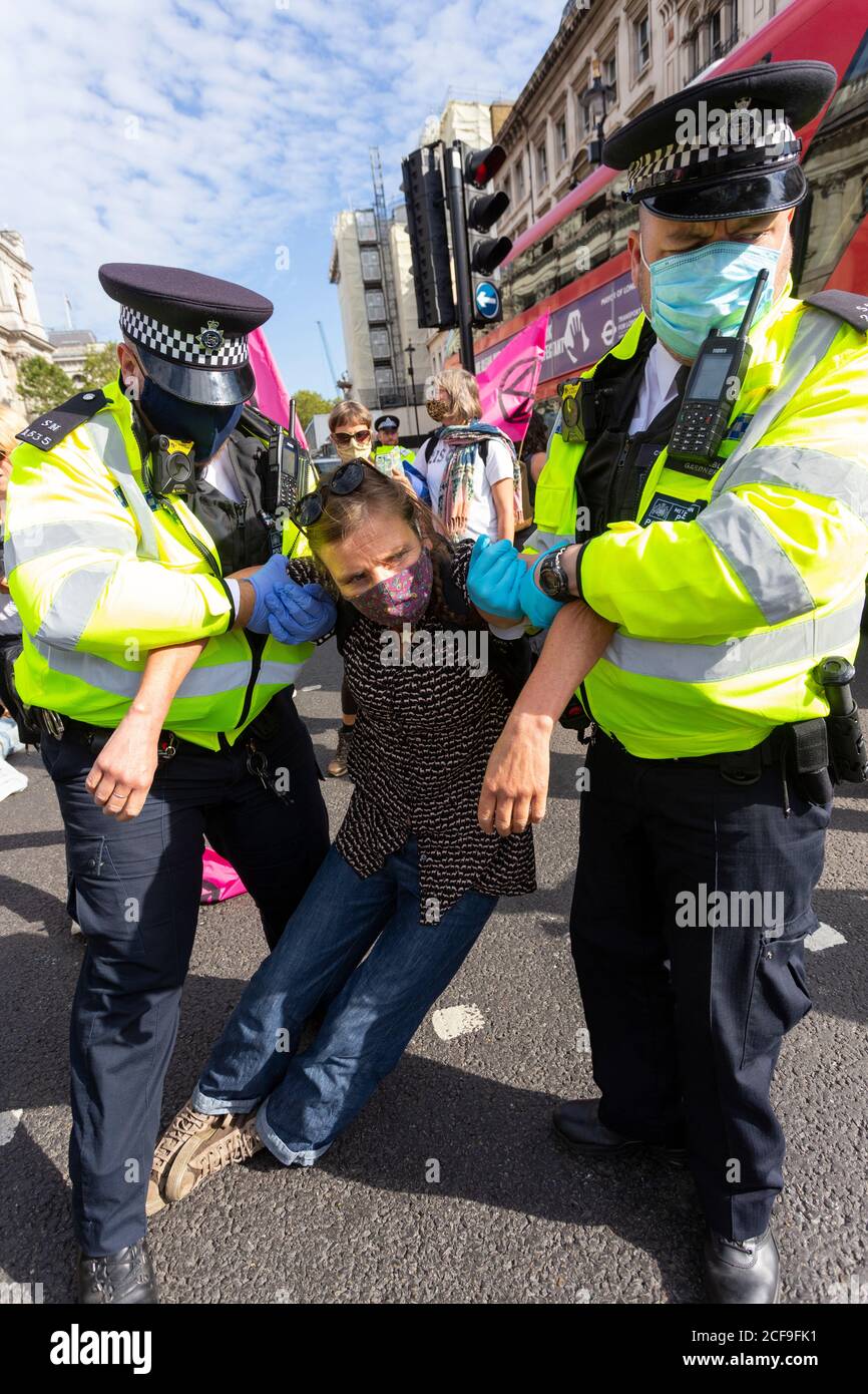 Die Polizei bringt eine verhaftete Frau weg, Demonstration des Extinction Rebellion, Parliament Square, London, 2. September 2020 Stockfoto