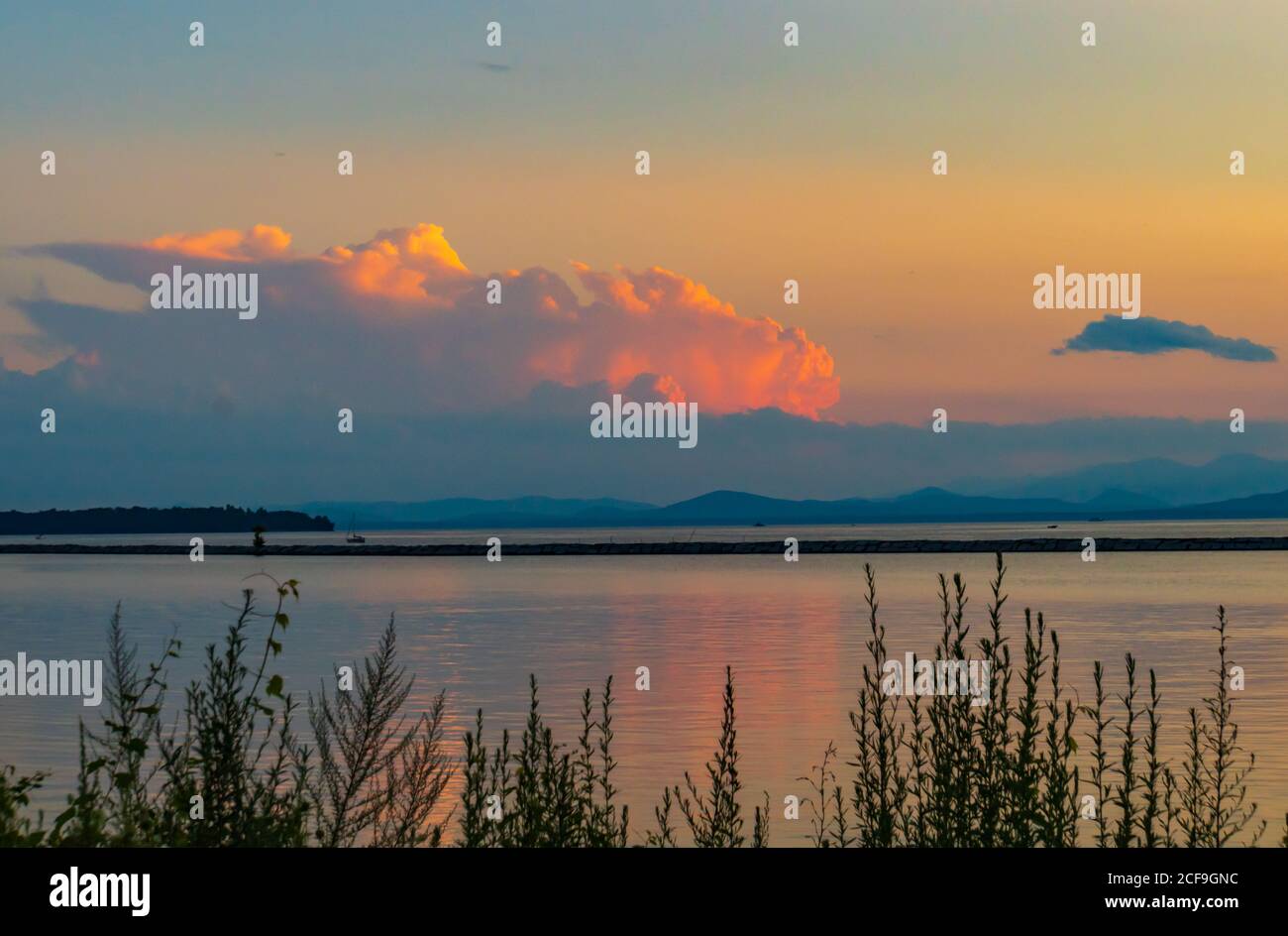 Untergehende Sonne erleuchtet die Wolken am Ufer des Lake Champlain in Burlington, Vermont Stockfoto