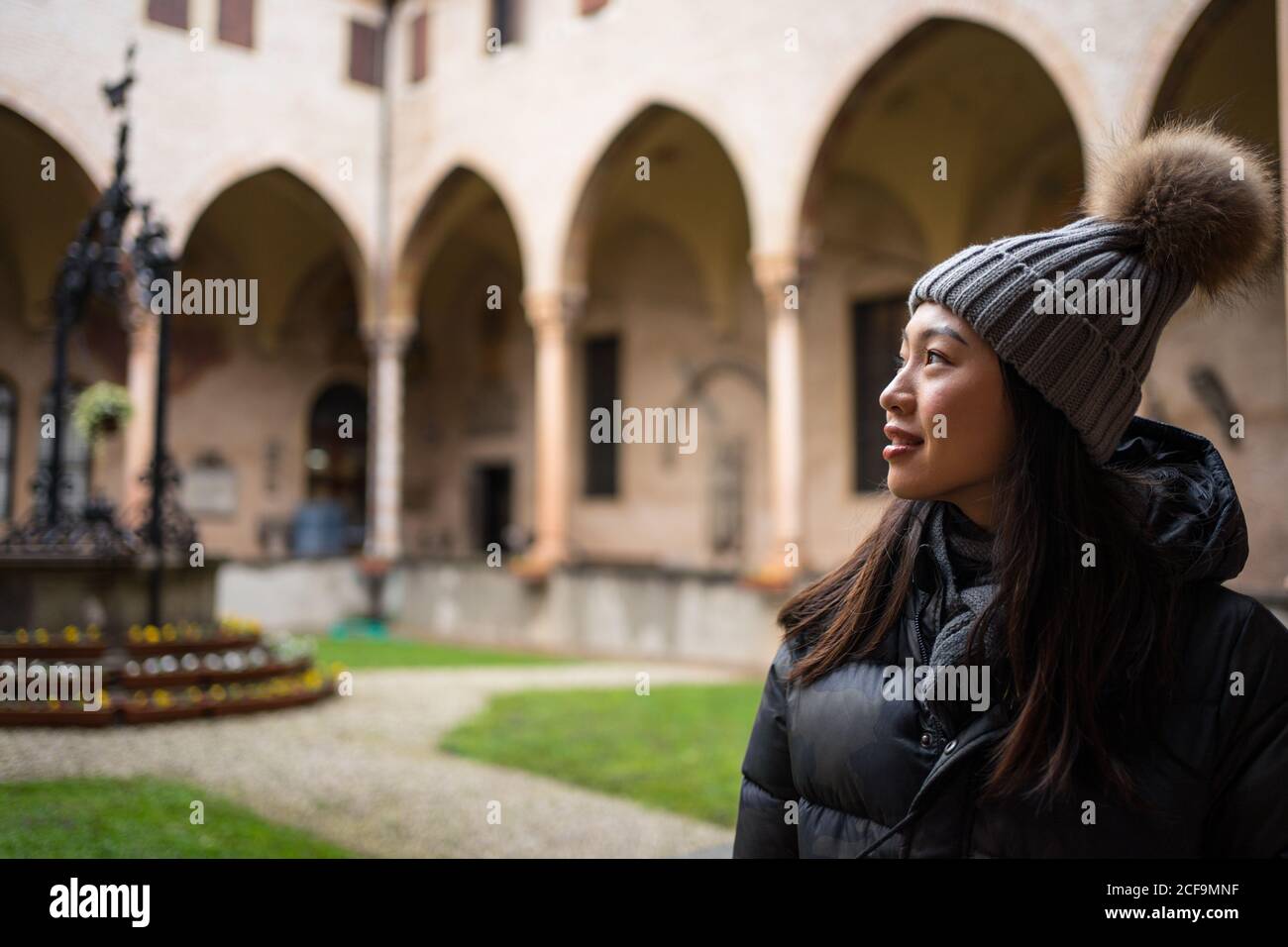 Neugierige ruhende asiatische Frau in warmer Kleidung und Hut erkunden schöne alte Basilica di Sant Antonio di Padova Stockfoto