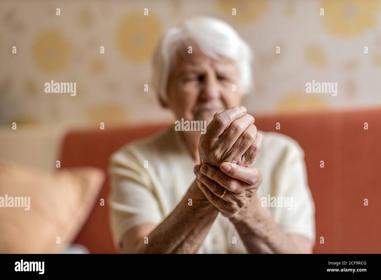 Ältere Frau mit reibenden Händen der Arthritis Stockfoto