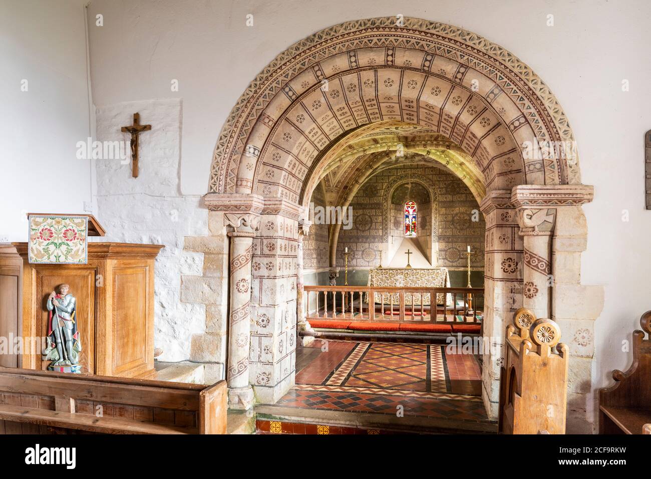 Die normannische Kirche St. George im Cotswold-Dorf Hampnet zeigt den Chor aus dem 12. Jahrhundert, der in den 1870er Jahren vom damaligen Vikar dekoriert wurde. Stockfoto