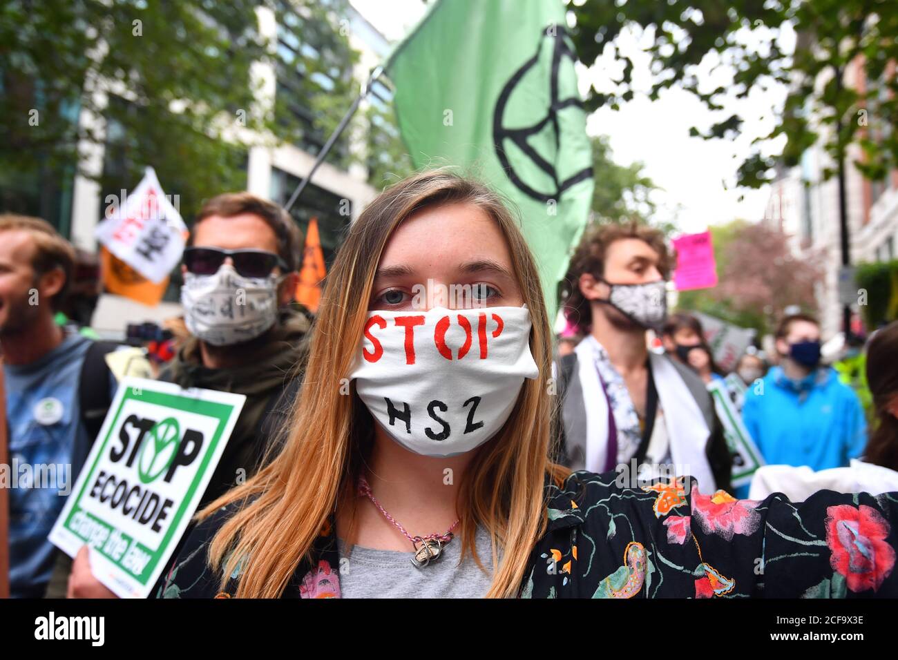 Ein Protestler trägt eine Stop HS2 Facemask neben Extinction Rebellion Demonstranten vor dem Department of Transport in Westminster, London, während eines Extinction Rebellion Protestes. Stockfoto