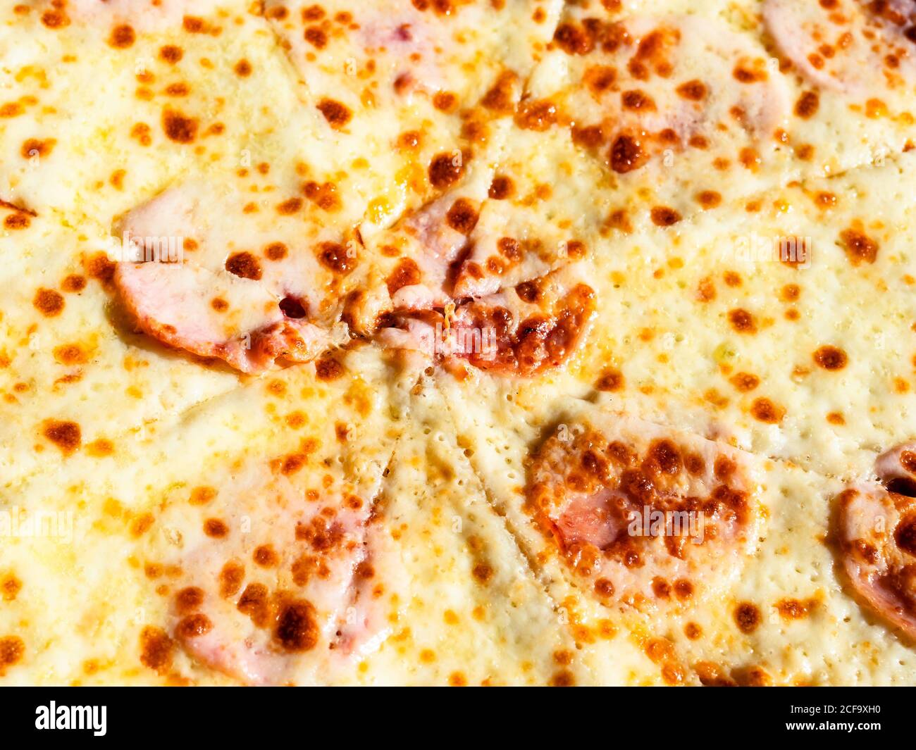 Oberfläche der italienischen Pizza mit Schinken von der Abendsonne beleuchtet Stockfoto
