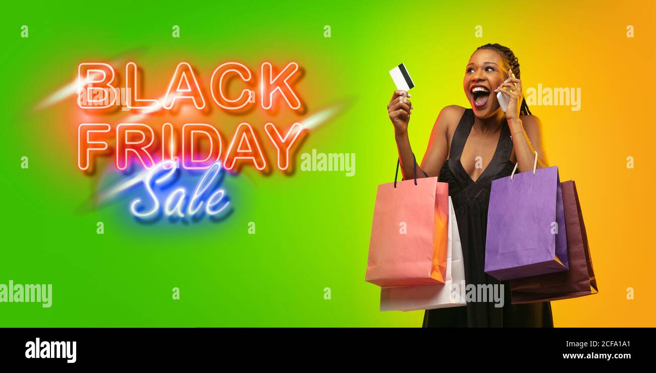 Erstaunt. Porträt einer jungen Frau in Neon auf Gradient Studio Backgound. Menschliche Emotionen, Black friday, Cyber monday, Käufe, Verkäufe, Finanzierungskonzept. Copyspace. Nahtlose Post für instagram. Stockfoto