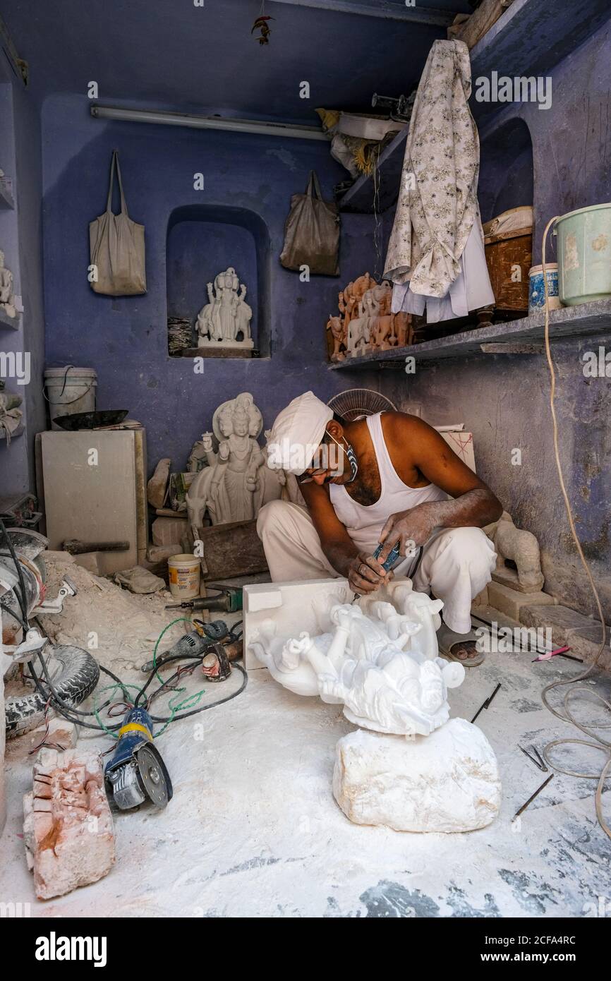 Jaipur, Indien - August 2020: Ein Handwerker arbeitet an einer Marmorstatue in der Altstadt von Jaipur am 27. August 2020 in Rajasthan, Indien. Stockfoto