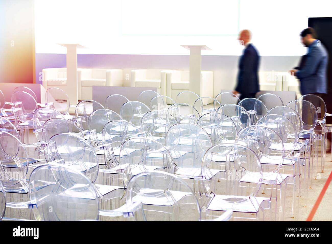 Transparente Plastikstühle im Konferenzraum und Personen Stockfoto