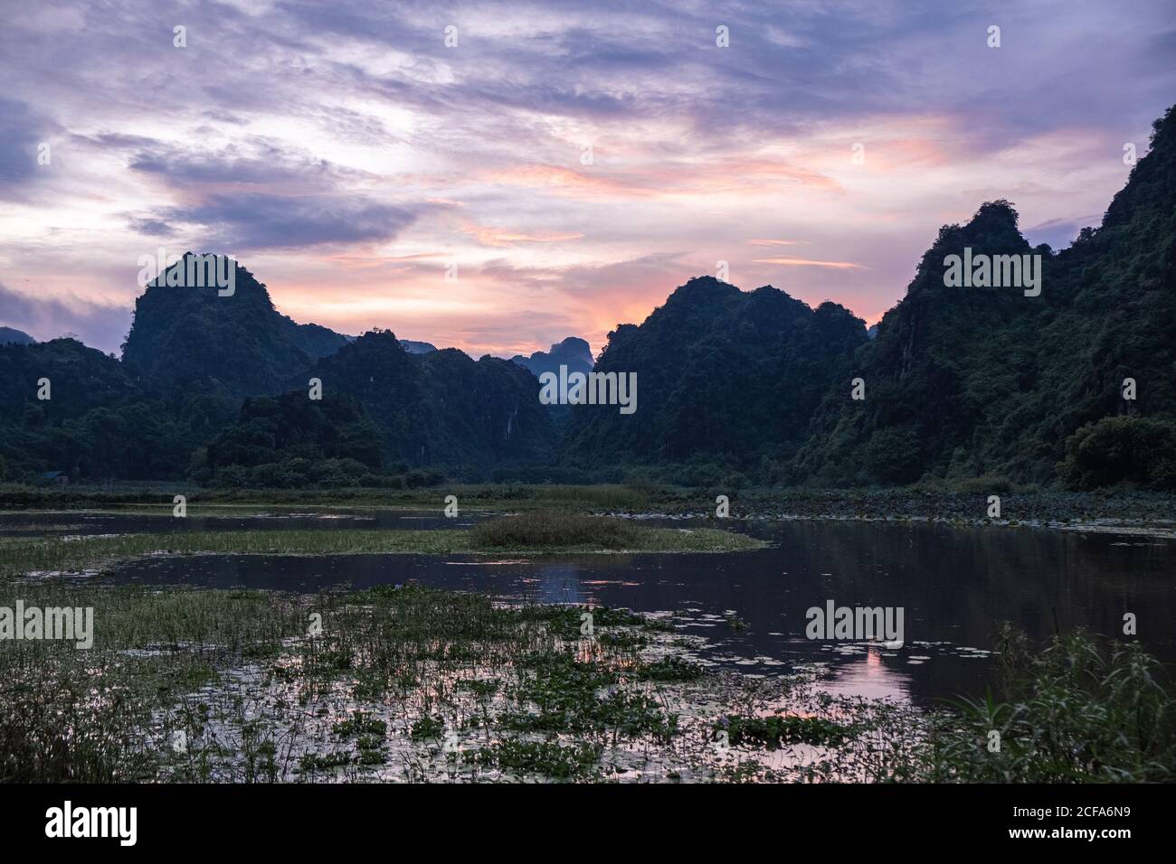 Wunderbare Landschaft mit bunten Sonnenuntergang und grünen Bergen in sumpfigen Terrain in Japan Stockfoto