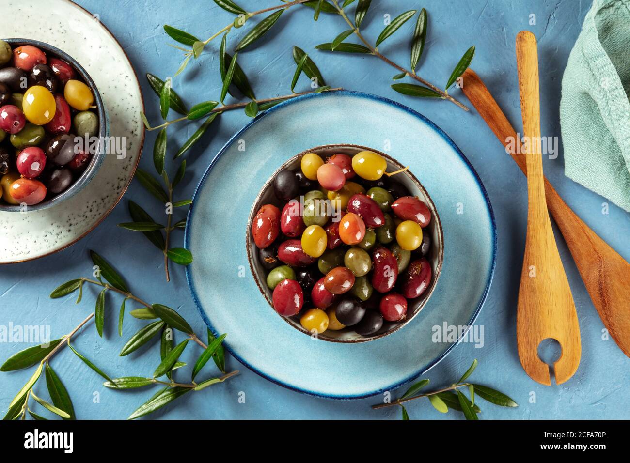 Oliven. Eine Vielzahl von grünen, schwarzen und roten Oliven, mit Blättern, von oben geschossen Stockfoto