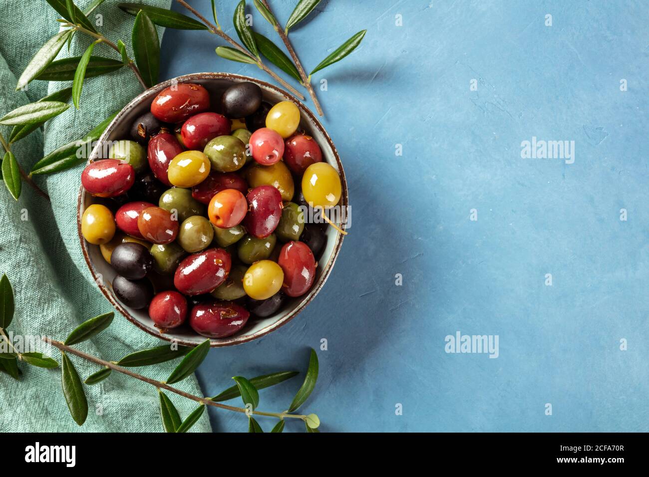 Oliven. Eine Vielzahl von grünen, schwarzen und roten Oliven, mit Blättern, von oben geschossen mit einem Platz für Text Stockfoto