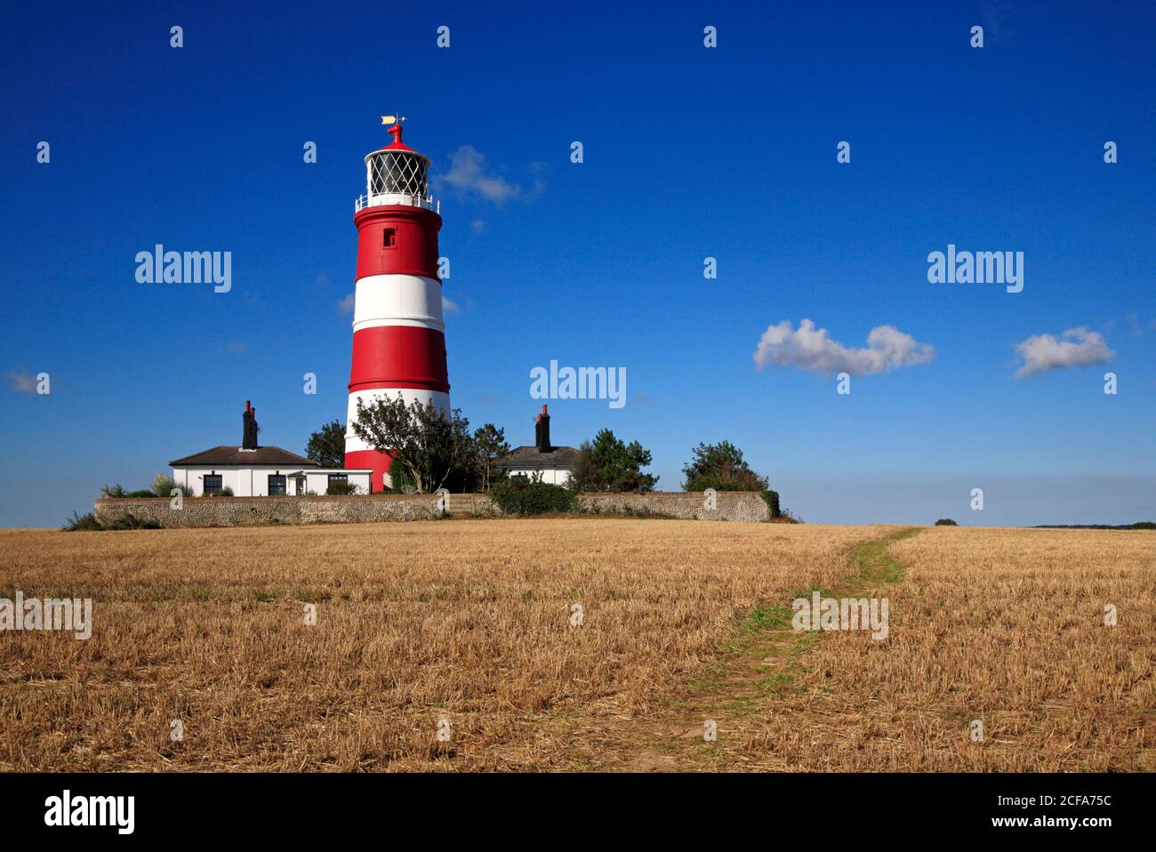 Ein Blick auf einen Wanderweg über Ackerland am unabhängig betriebenen Leuchtturm an der Nord-Norfolk-Küste in Happisburgh, Norfolk, England, Großbritannien. Stockfoto