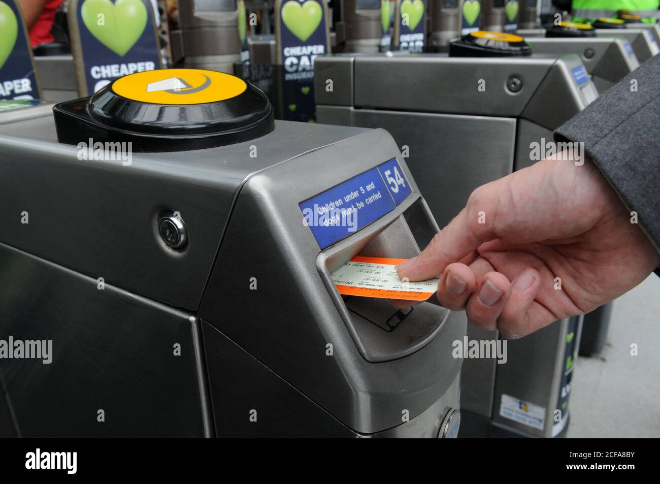 Hand setzen Zug-Ticket in eine TFL-Stationen Ticket Barriere im Großraum London. Stockfoto