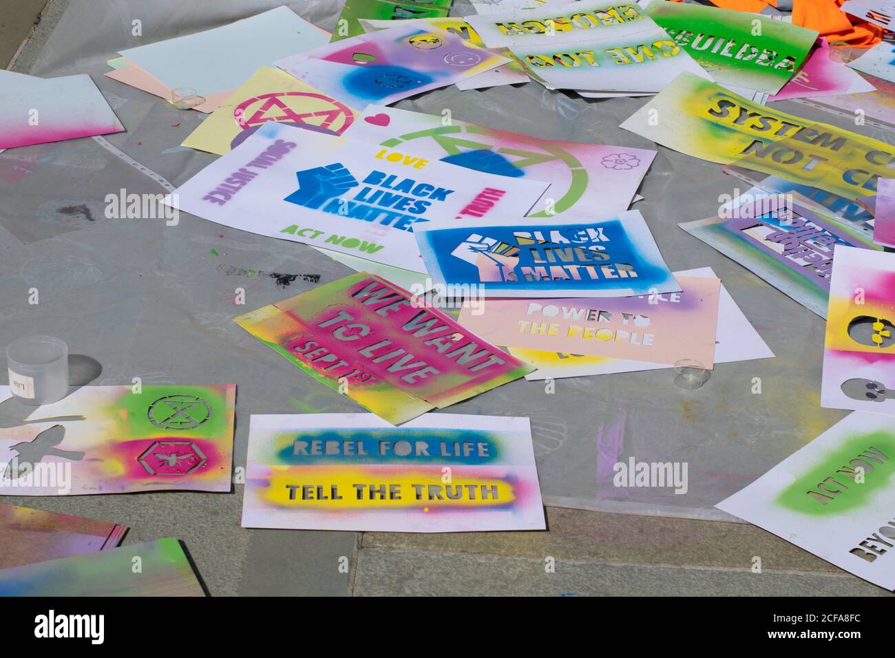 Schablonensprühen mit wischbarer Kreidefarbe. Slogans, Rebel for Life, Black Lives Matter, We Want to live. Extinction Rebellion Protest Manchester, Großbritannien Stockfoto