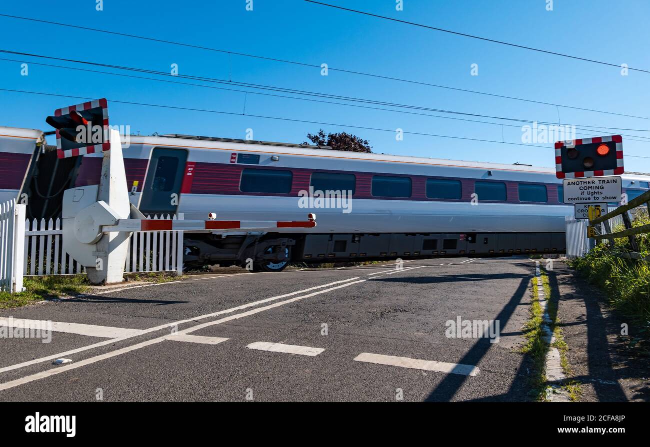 LNER Azuma Zug auf East Coast Hauptlinie Bahnlinie Bahnübergang mit Blinklicht, Markle, East Lothian, Schottland, UK Stockfoto