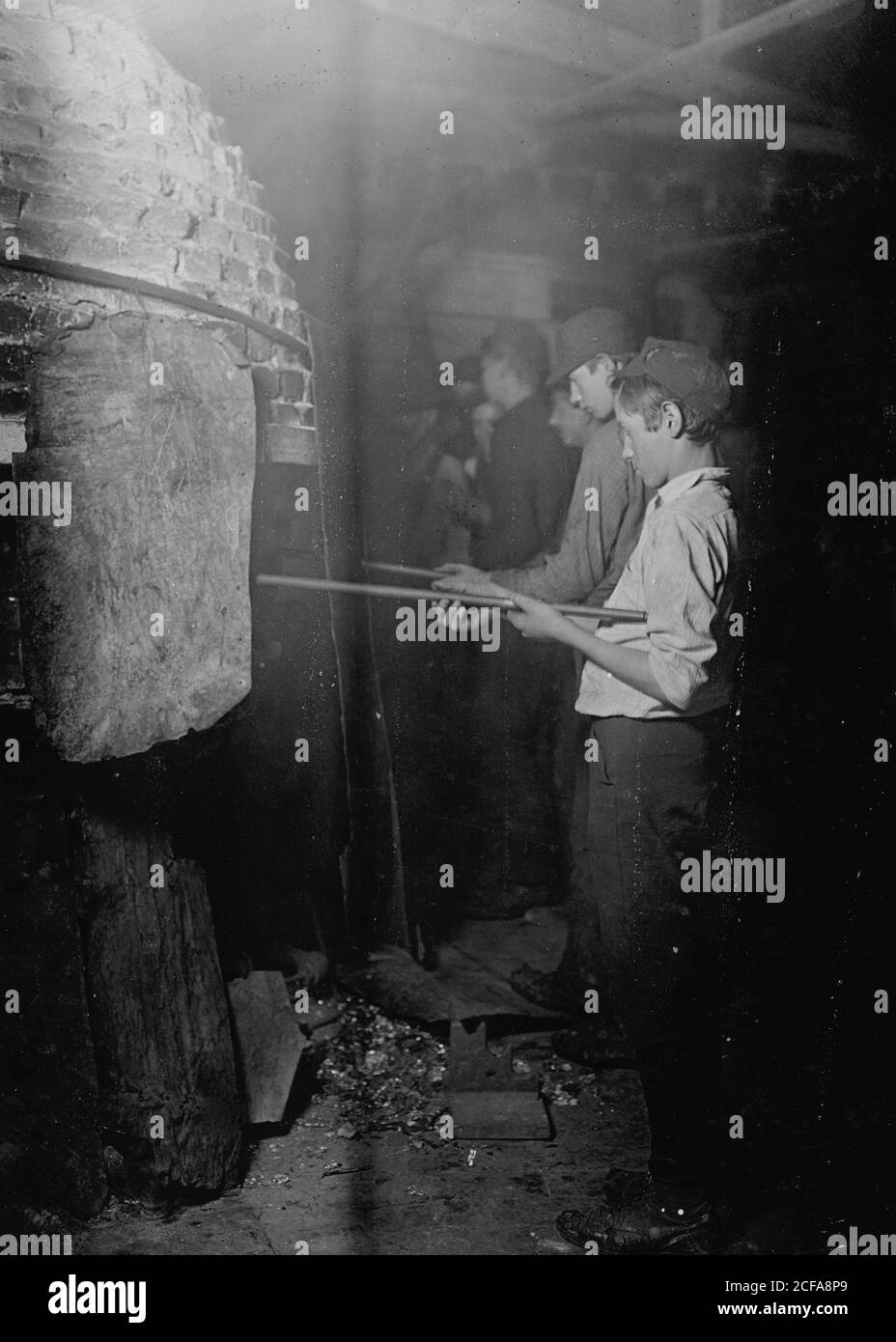 Mitternacht in einer Glashütte in Grafton, W. VA. Jungs am "Glory-Hole" wo Objekt aufgewärmt ist, vor dem Schlafengehen finisher Stockfoto