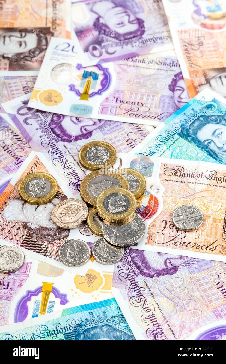 Neue britische Pfund Polymer-Banknoten und Münzen verstreut Stockfoto