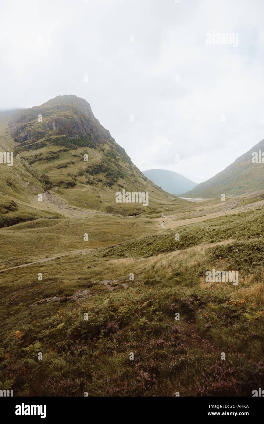 Malerischer Blick auf grünes Tal durch hohe Felsen in Glencoe Am Tag Stockfoto