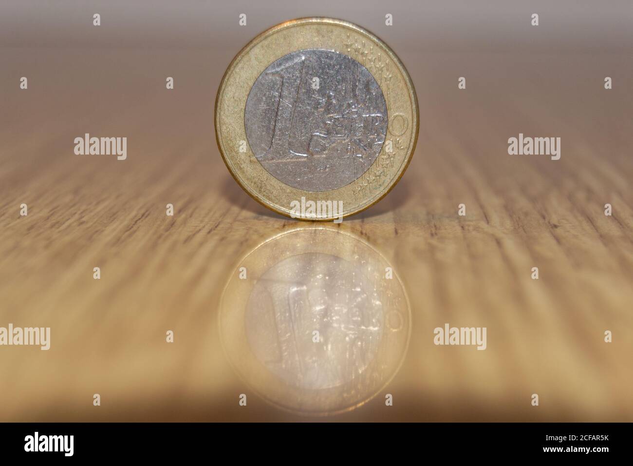 1-Euro-Münze mit Spiegelung auf dem Tisch Stockfoto
