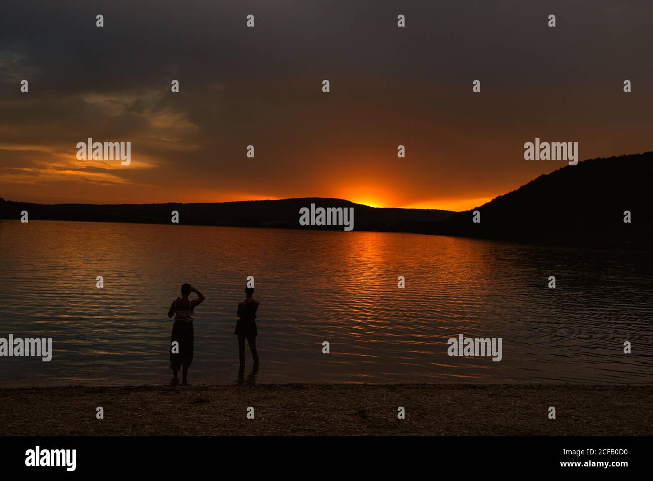 Sonnenuntergang über dem Chalain See mit zwei Damen bewundern die Aussicht, Frankreich Stockfoto