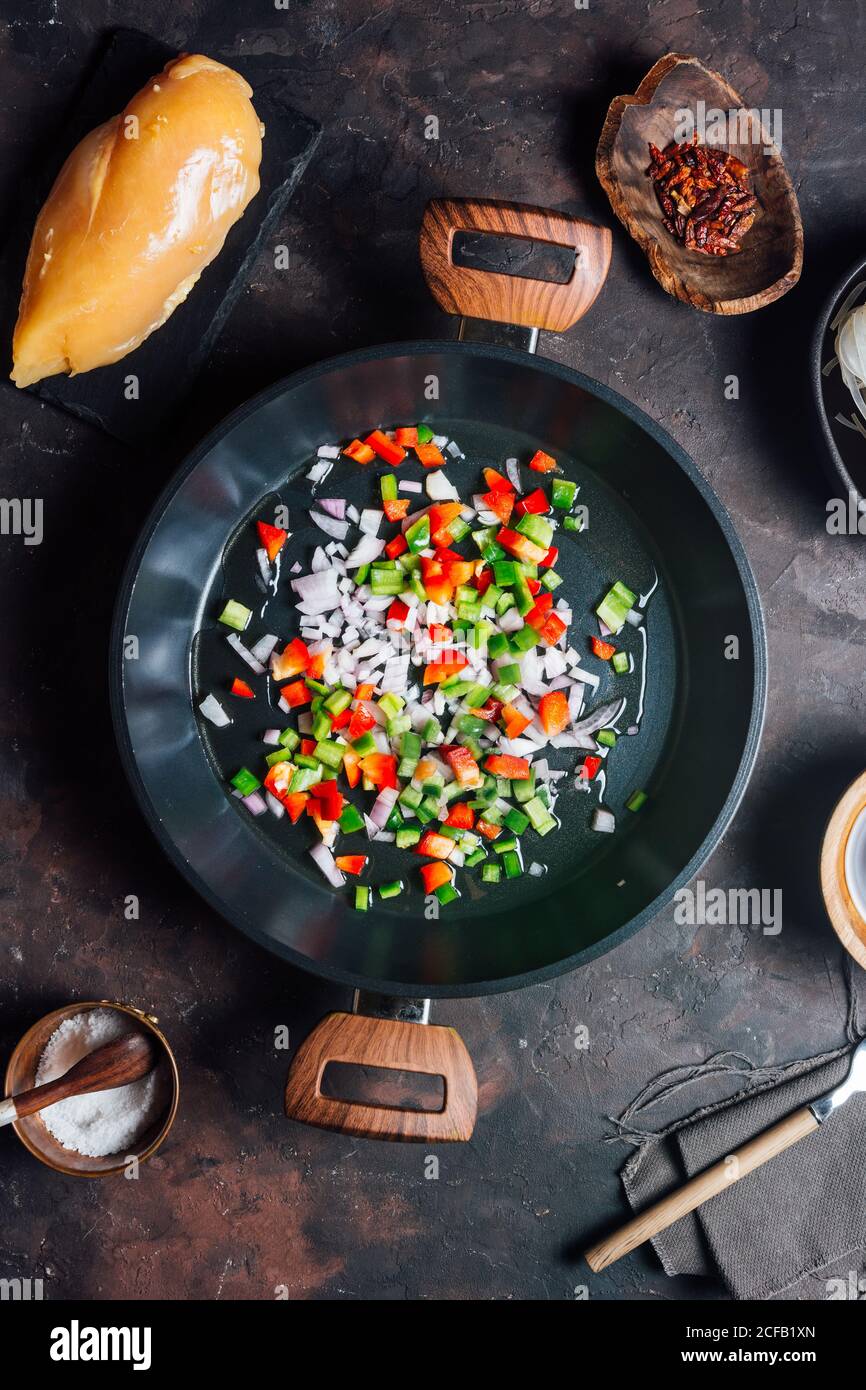 Draufsicht auf die Pfanne mit dem Mischen von gehacktem Pfeffer und Zwiebeln Zum Abendessen Stockfoto