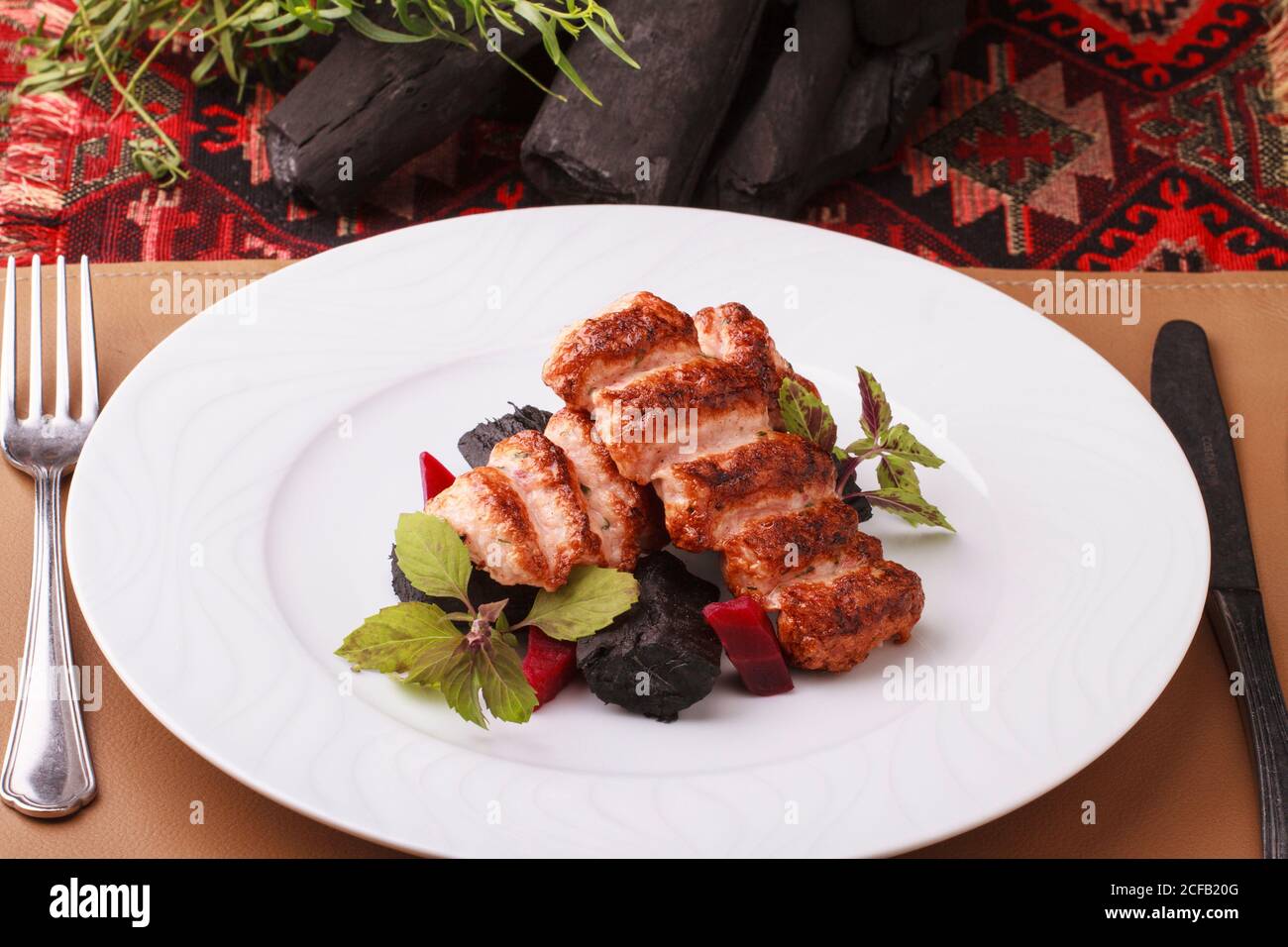 Gehackte Garnelen/Garnelen Schischebab serviert mit Rote Bete und essbare Kohle. Stockfoto