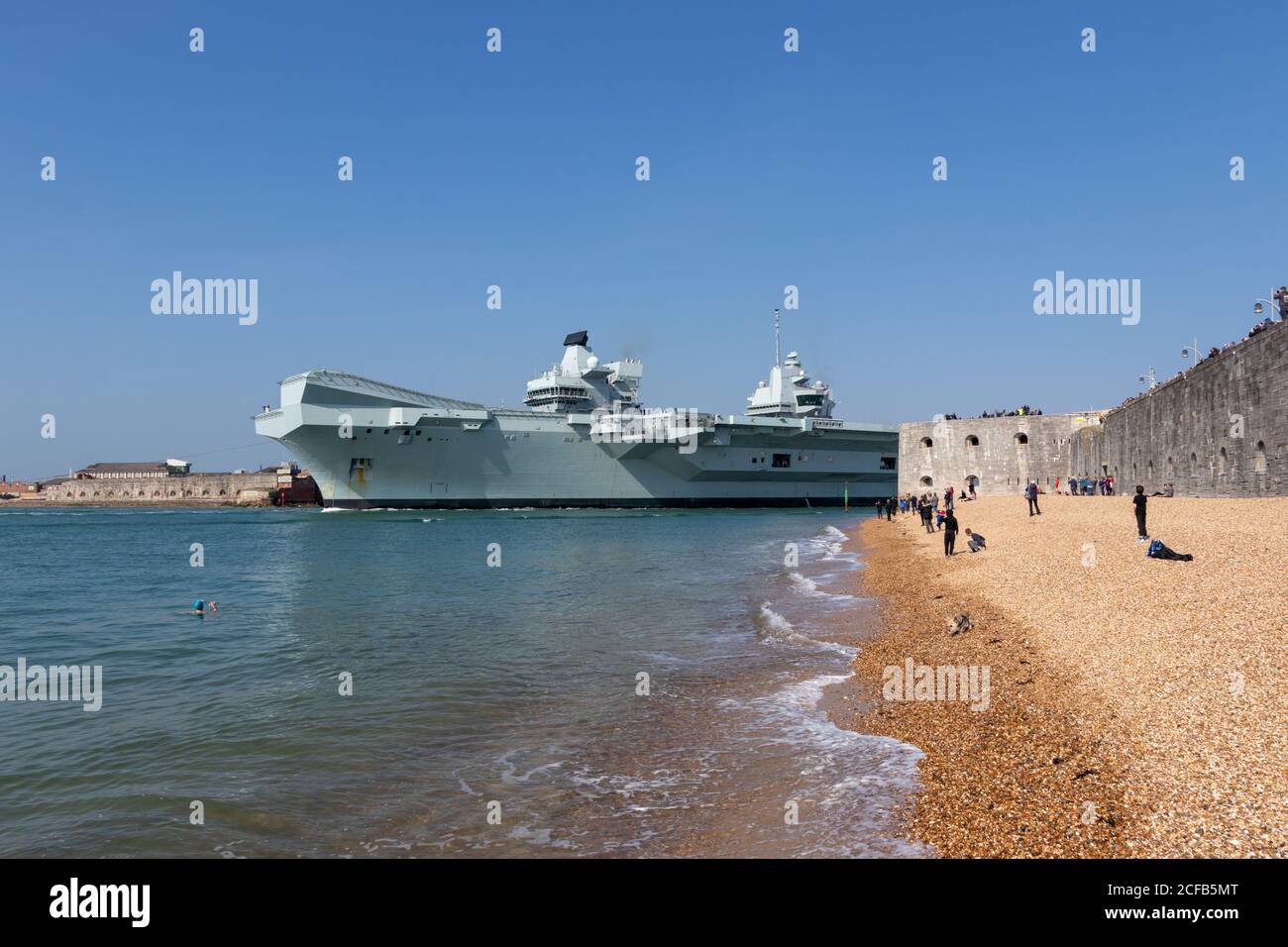 HMS Queen Elizabeth verlässt Portsmouth Hafen mit Menschen versammeln sich zu Beobachten Sie, wie es den runden Turm passiert Stockfoto