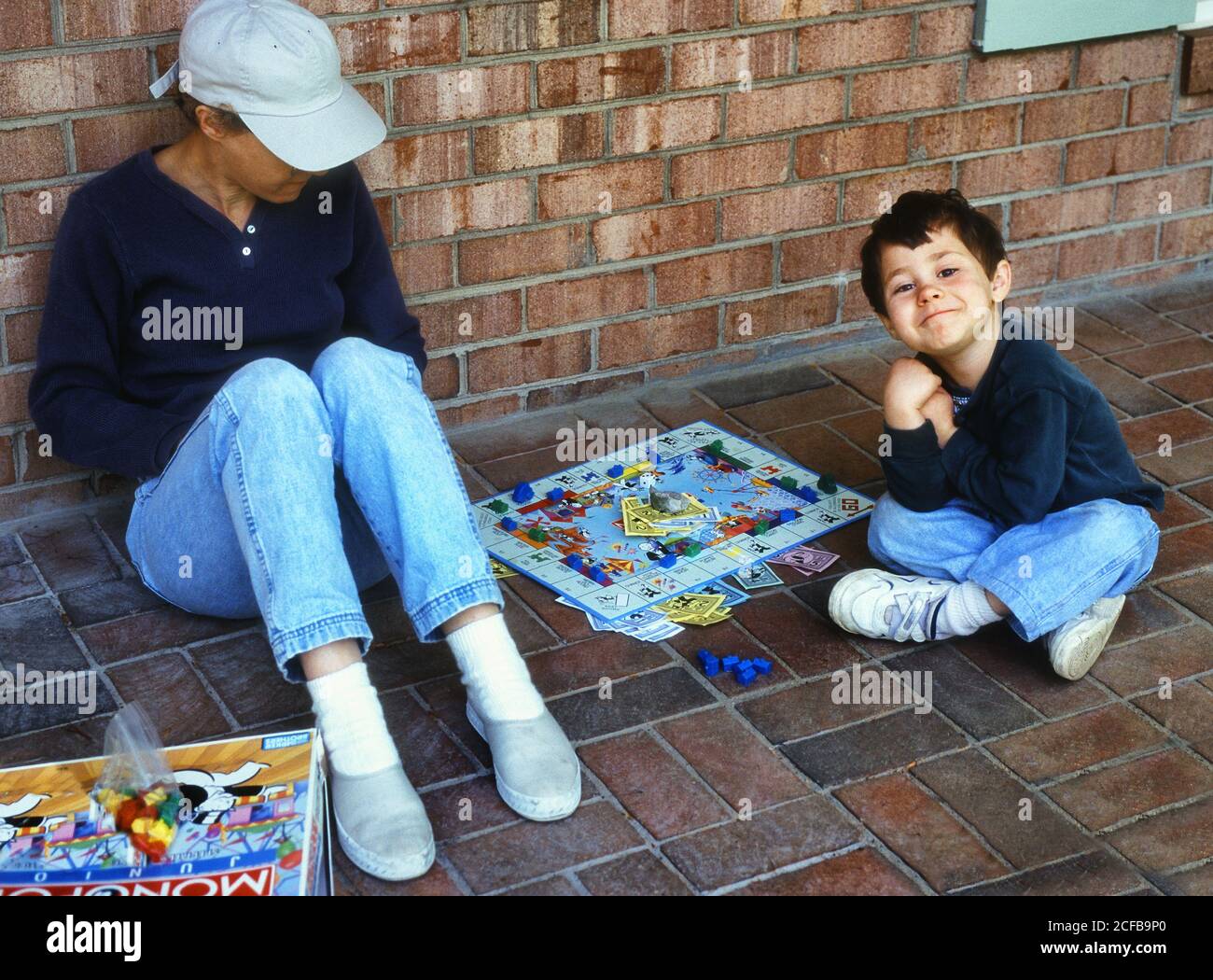 Junge spielen Monopoly mit Mutter Stockfoto