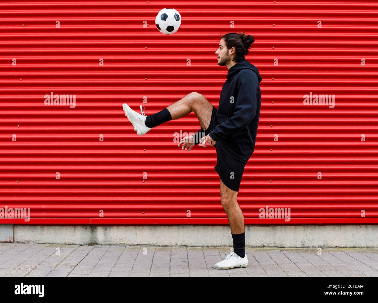 Mann spielt Fußball auf der Straße Stockfoto