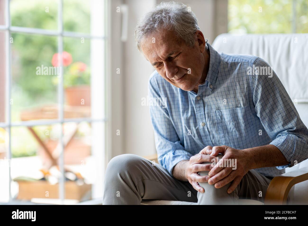 Ältere Menschen mit Schmerzen im Knie Stockfoto