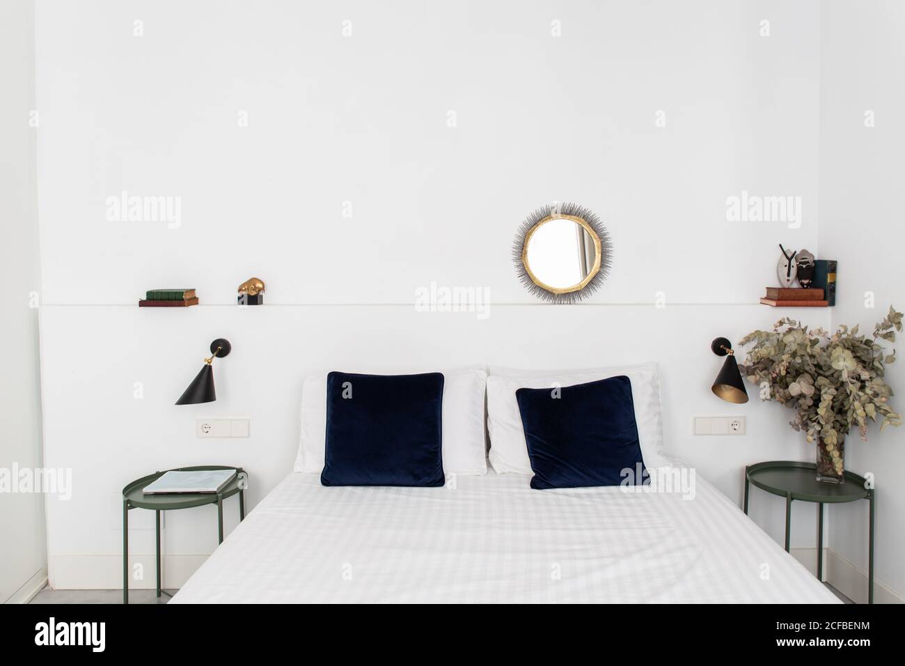 Komfortables Bett mit weißer Federdecke in gemütlichem, modernen Schlafzimmer Wohnung Stockfoto