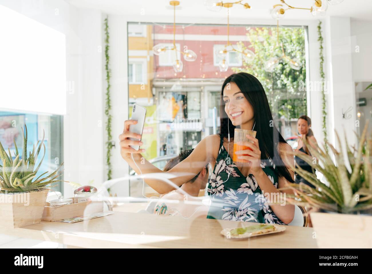 Dame mit einem gesunden Getränk, die Selfie im Café nimmt Stockfoto