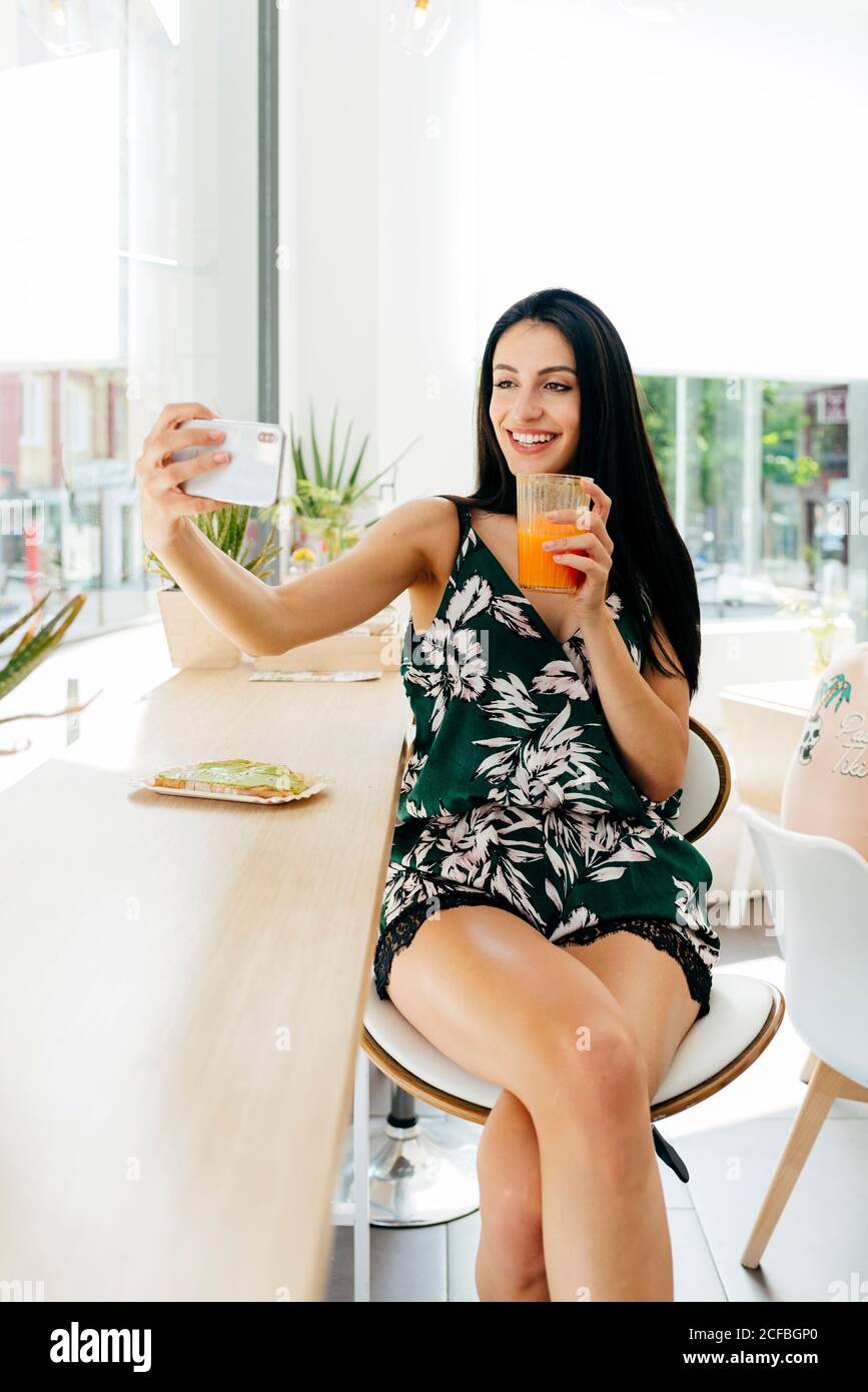 Dame mit einem gesunden Getränk, die Selfie im Café nimmt Stockfoto