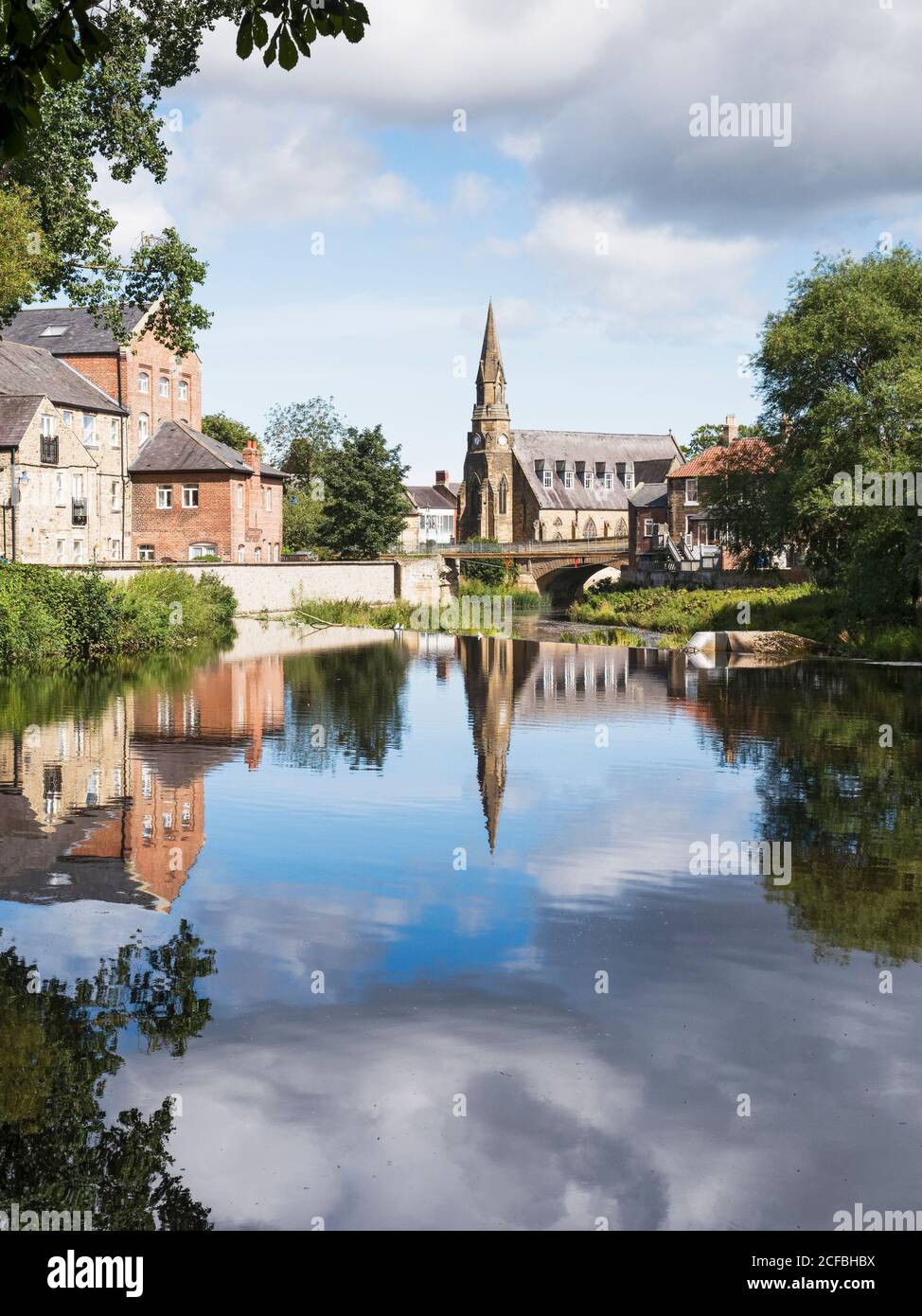 Blick auf den Fluss Wansbeck in Morpeth, Northumberland, Großbritannien mit St. Georges United Reformierte Kirche. Stockfoto