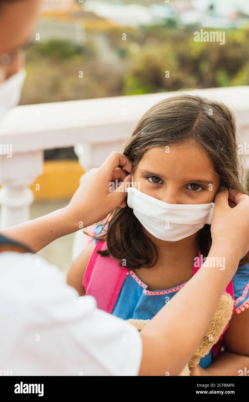 Bruder zieht ihrer Schwester sterile medizinische Maske an. Kind, trägt Gesichtsmaske, vor Infektionen von Viren, Pandemie, Ausbruch und Epidemie von Krankheiten zu schützen Stockfoto