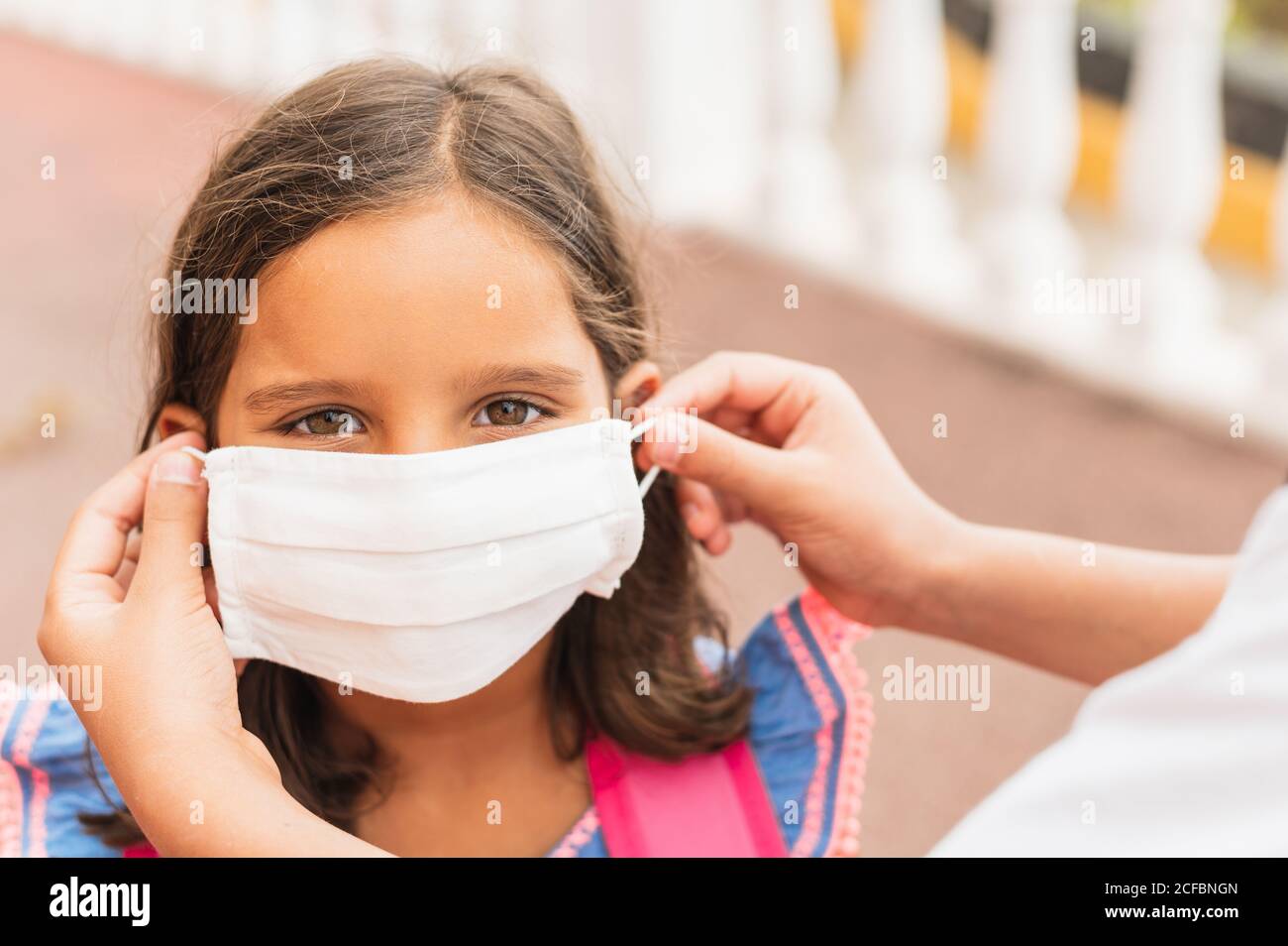 Mutter zieht ihr Kind sterile medizinische Maske an. Kind, tragen Gesichtsmaske, vor Infektionen von Viren, Pandemie, Ausbruch und Epidemie der Krankheit zu schützen Stockfoto