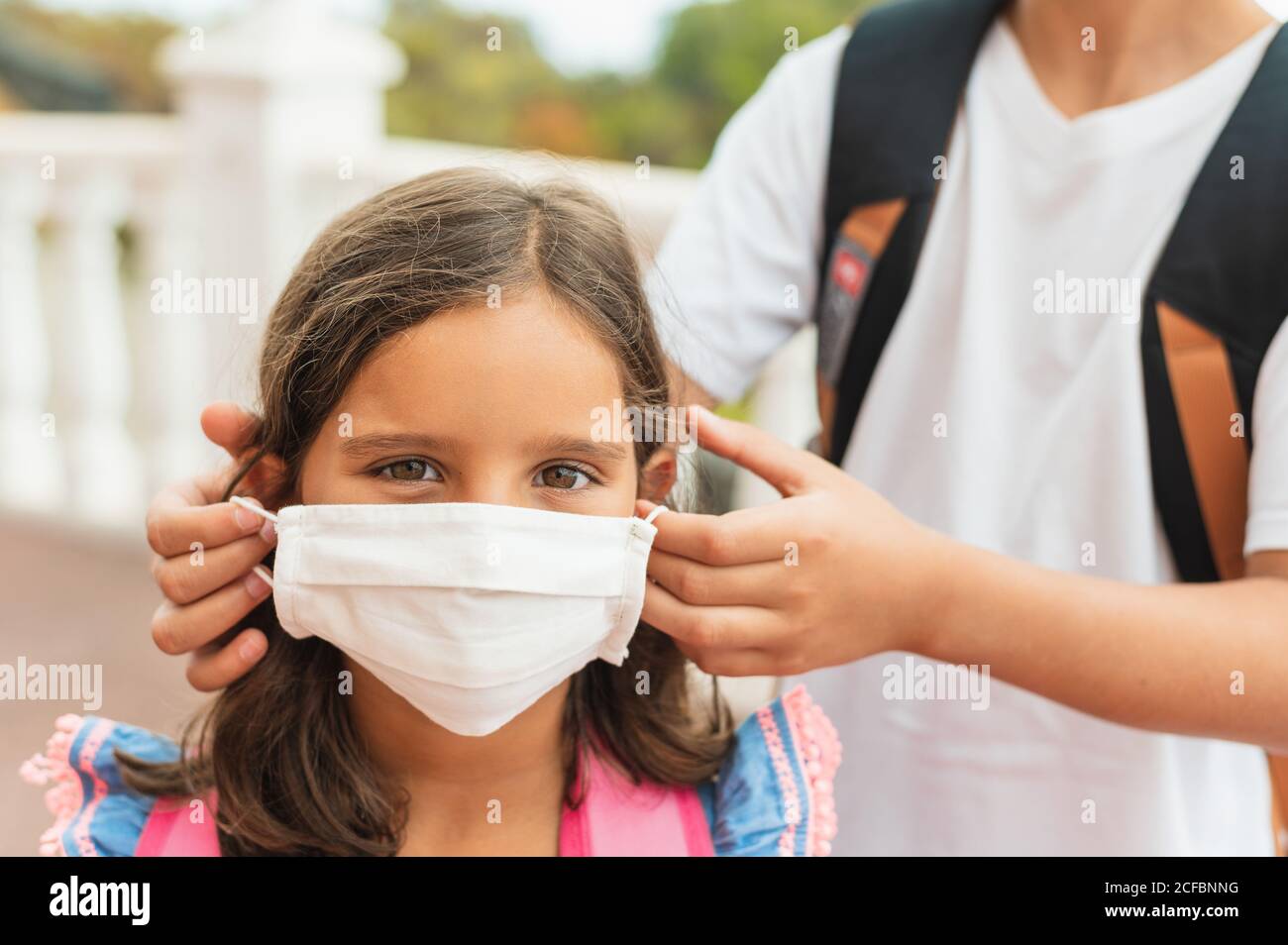 Bruder zieht ihrer Schwester sterile medizinische Maske an. Kind, trägt Gesichtsmaske, vor Infektionen von Viren, Pandemie, Ausbruch und Epidemie von Krankheiten zu schützen Stockfoto