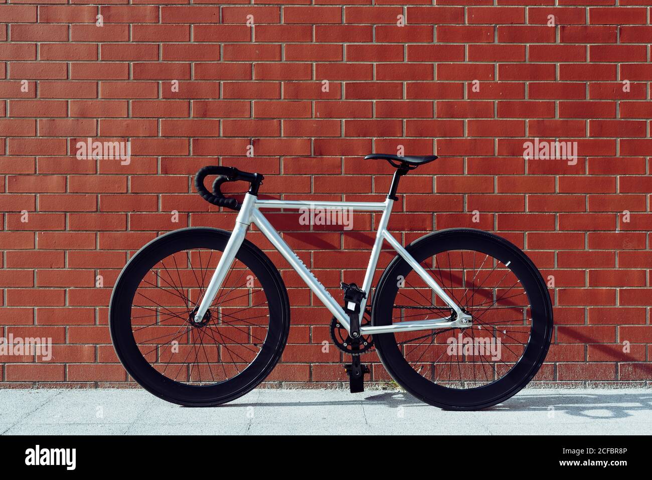 Neues modernes weißes Rennrad mit schwarzer Griffstange geparkt Gegen rote  Backsteinmauer Stockfotografie - Alamy