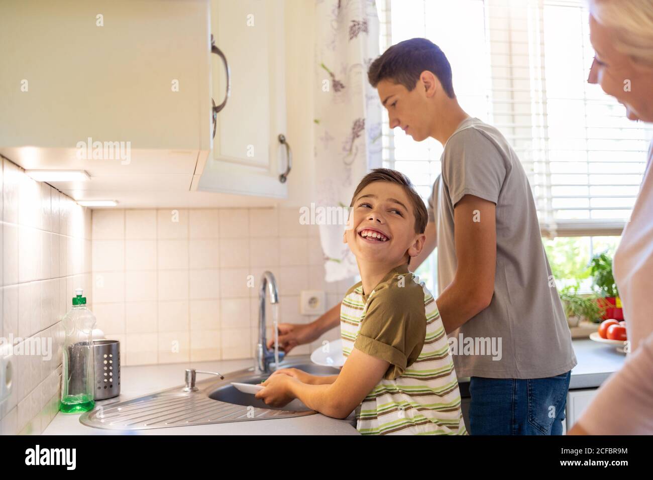 Zwei Jungen waschen das Geschirr im Spülbecken Stockfoto